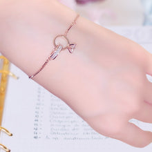 Load image into Gallery viewer, Image shows rose gold Amadeus Charm Bracelet on model's wrist.