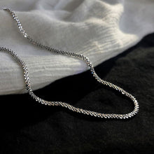 Load image into Gallery viewer, Image shows Arianwyn Chain lying on black and white fabrics.
