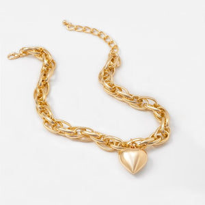 Image shows gold-finish Cathy Heart Necklace on a grey background.