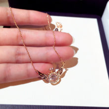Load image into Gallery viewer, Image shows gold-finish Gloria Angel Necklace resting on a model&#39;s fingers.
