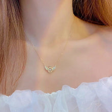 Load image into Gallery viewer, Image shows gold-finish Gloria Angel Necklace on a model.

