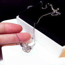 Load image into Gallery viewer, Image shows silver-finish Gloria Angel Necklace resting on a model&#39;s fingers.
