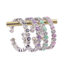 Load image into Gallery viewer, Image shows Black, Purple, Light Green and Pink silver-tone rings on a ring stand.
