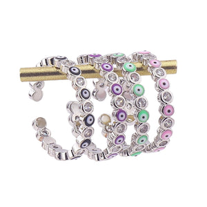 Image shows Black, Purple, Light Green and Pink silver-tone rings on a ring stand.